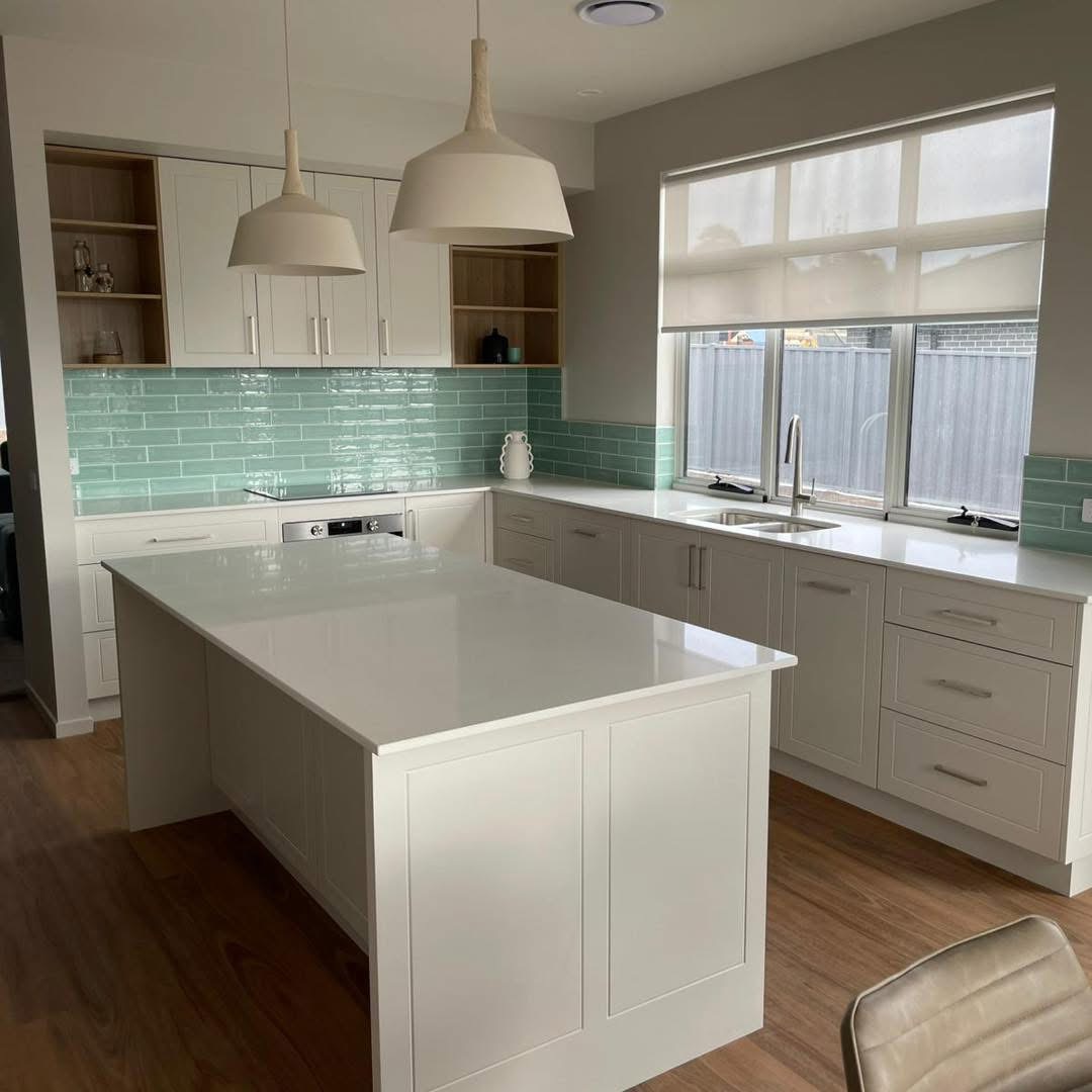 White shaker kitchen with a mint green splashback and stone island, built by Central Coast Joinery